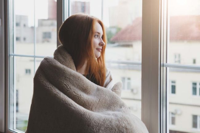 what-is-rehab-like a woman staring out a window wondering what is rehab like